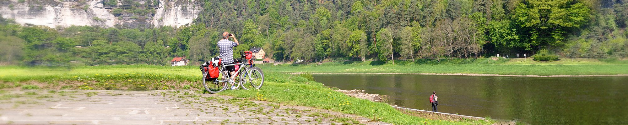 Mann mit Fahrrad schaut auf das Elbsandsteingebirge