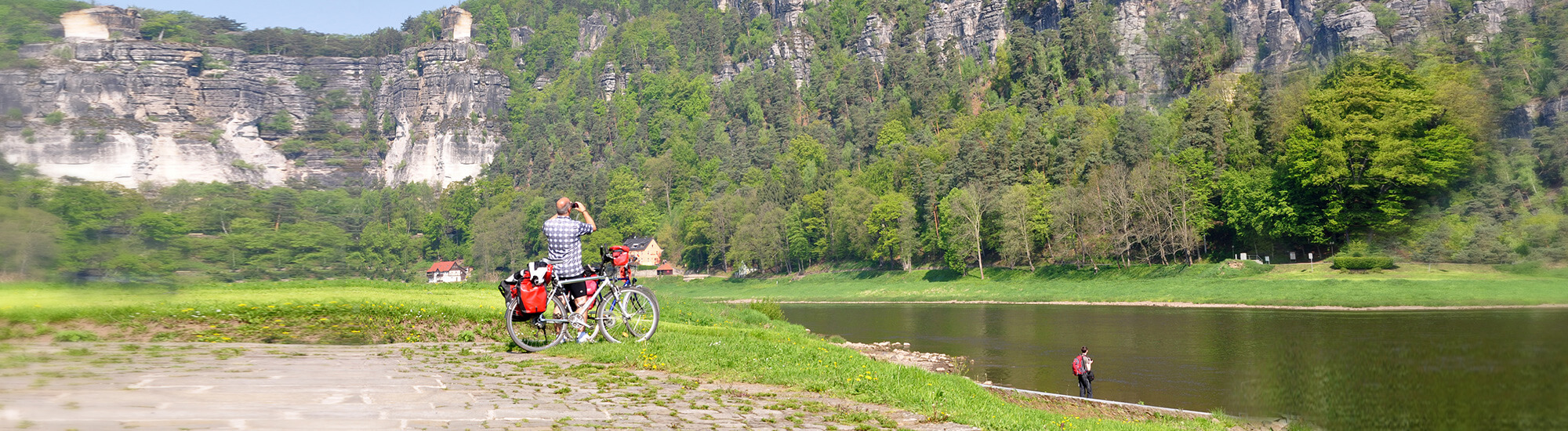 Mann mit Fahrrad schaut auf das Elbsandsteingebirge